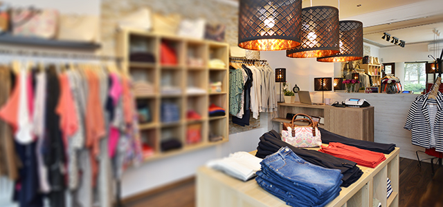 Innenansicht von einem Damenmodegeschäft mit Waren an Ständern und in Regalen