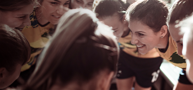 Damenfußballmannschaft bildet einen Mannschaftskreis – Symbolbild für eine Vereinshaftpflichtversicherung