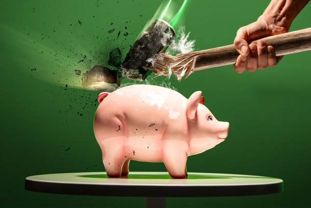 Eine Hand mit einem Hammer versucht ein Sparschwein zu zerschlagen, allerdings wiedersteht das Sparschwein und stattdessen geht der Hammer kaputt – Symbilbild für WWK IntelliProtect